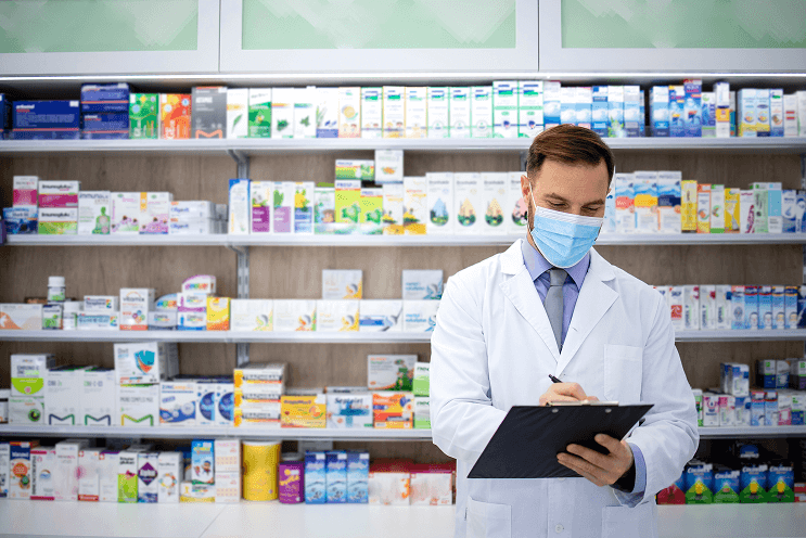 Pharmacist selling medicines in pharmacy shop
